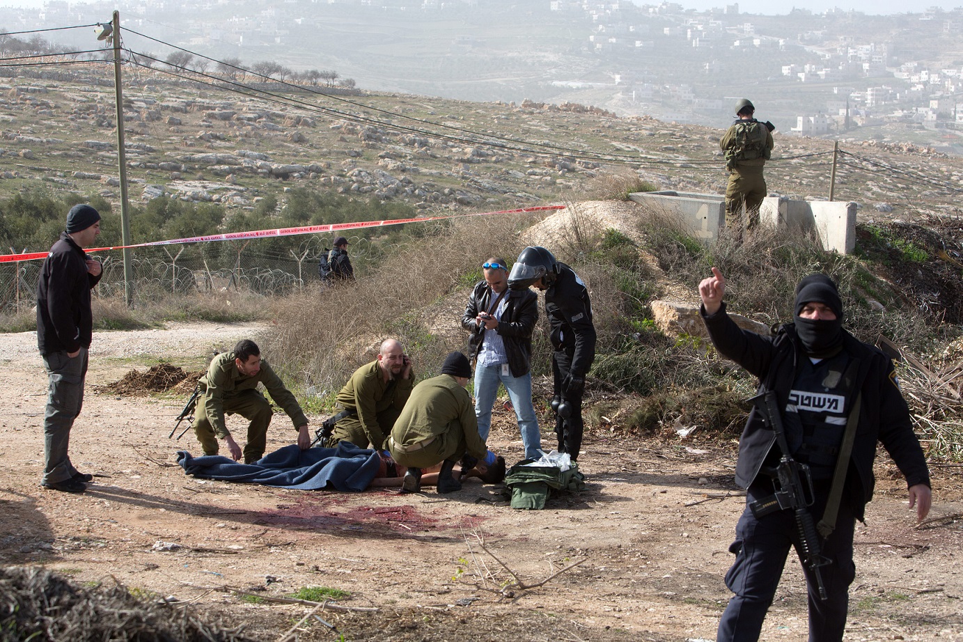 IDF forces treating a Palestinian shot after a stabbing attack in Tekoa. January 18, 2016. Photo: Menahem Kahane / AFP