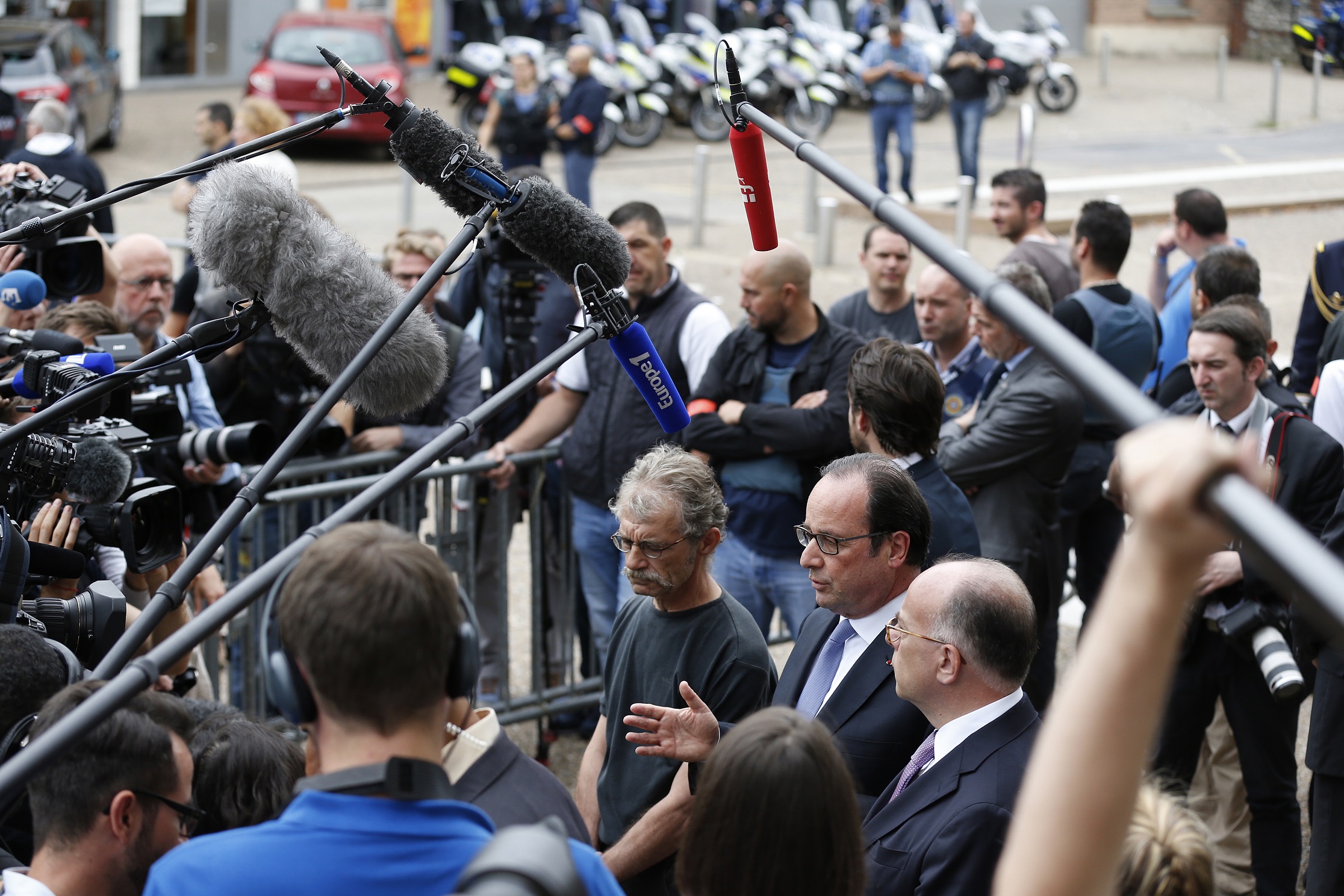 French President François Hollande (c), flanked by the mayor of Saint-Etienne-du-Rouvray and the French Interior Minister, following the terrorist attack at a town church, July 26, 2016. Photo: Charly Triballeau / AFP