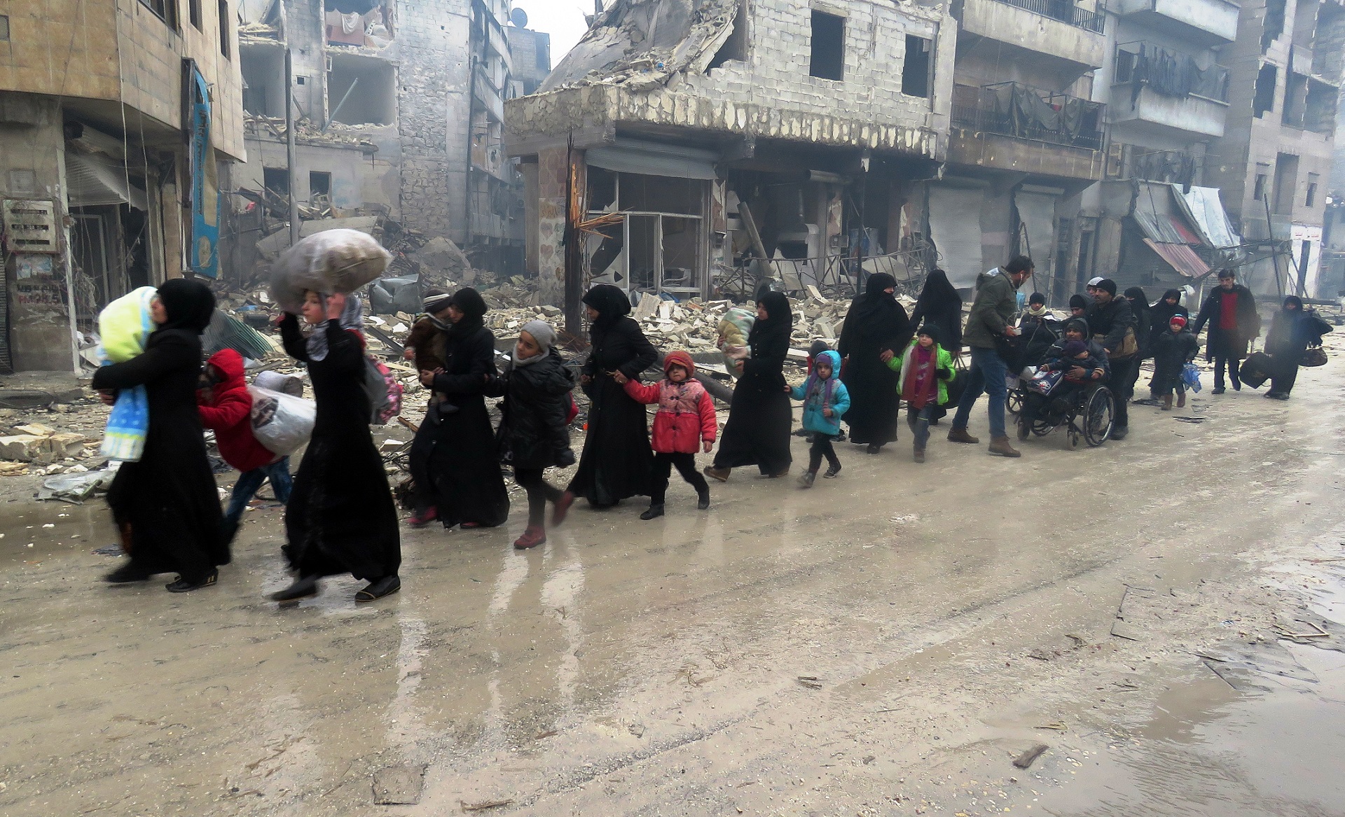 Residents of Aleppo fleeing their homes after regime troops retook the area from rebel fighters, December 13, 2016. Photo: Stringer / AFP