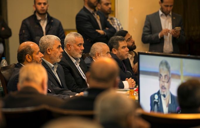 Yahya Sinwar and Ismail Haniyeh attend a gathering to watch the speech of Exiled Hamas Chief Khaled Meshaal (screen), in Gaza City on May 1, 2017