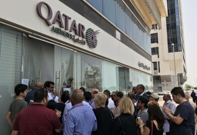 People gather outside a branch of Qatar Airways in the United Arab Emirate of Abu Dhabi on June 6, 2017