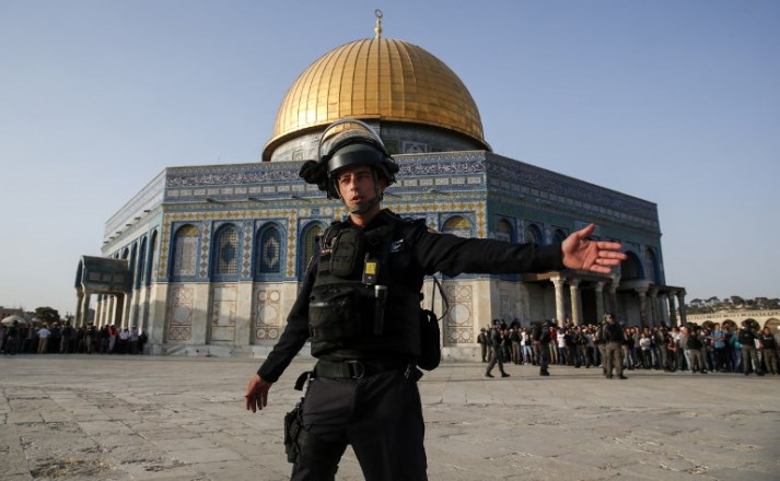 A member of the Israeli security forces gestures with his left arm as he stands before the Dome of the Rock, in the Haram al-Sharif compound in the old city of Jerusalem on July 27, 2017. Clashes erupted between Israeli police and Palestinians at the sensitive Jerusalem holy site on July 27, 2017 as thousands of Muslim worshippers entered to end a boycott of the compound over new Israeli security measures.