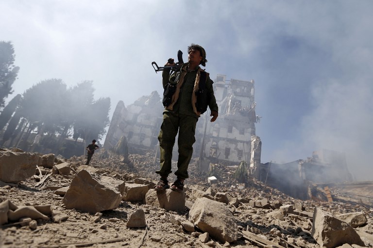 Huthi rebel fighters inspect the damage after a reported air strike carried out by the Saudi-led coalition targeted the presidential palace in the Yemeni capital Sanaa on December 5, 2017.
