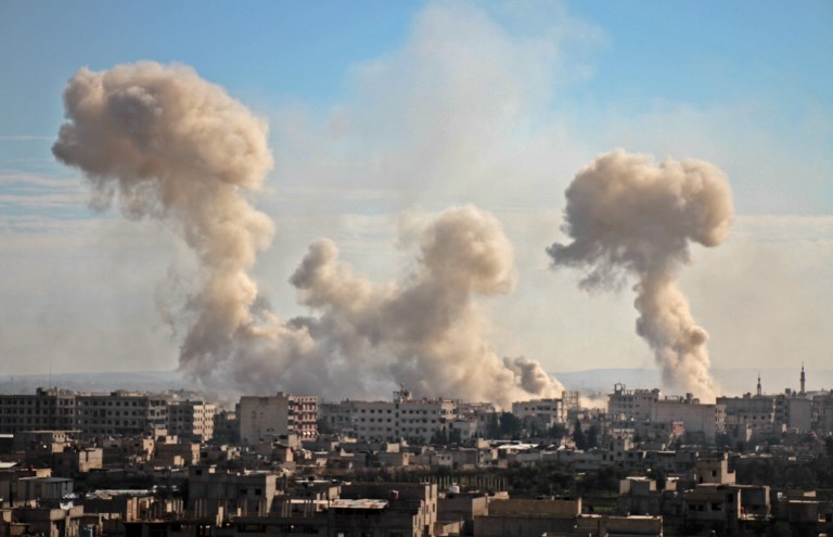 Smoke rises from buildings following bombardment on the village of Mesraba in the rebel-held besieged Eastern Ghouta region on the outskirts of the capital Damascus, on February 19, 2018.