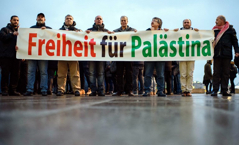Protesters hold a banner reading in German