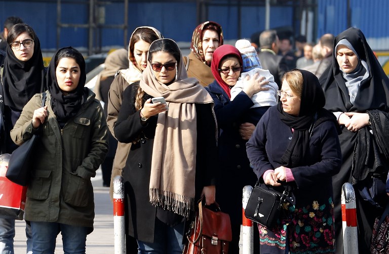 Iranian women wearing hijab walk down a street in the capital Tehran on February 7, 2018.
