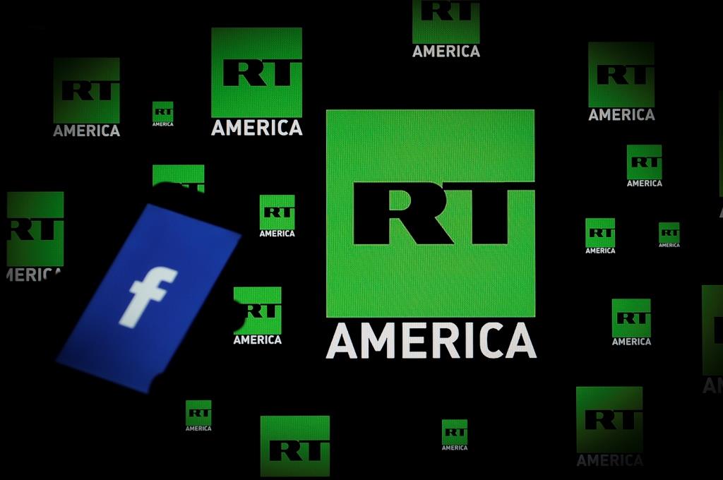 A Facebook logo is seen on a portable device with the logo of Russia Today (RT) news channel in the background in this photo illustration on November 15, 2017.