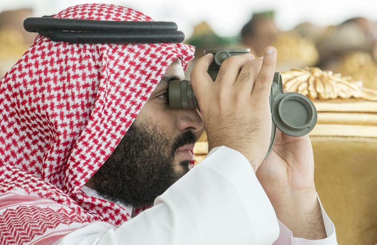 Saudi Arabia's Crown Prince Mohammed bin Salman using binoculars to follow the