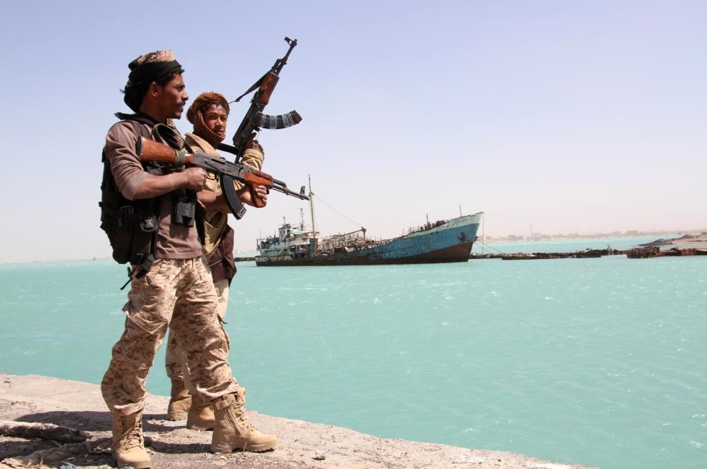 Pro-government forces walk in the port of the western Yemeni coastal town of Mokha