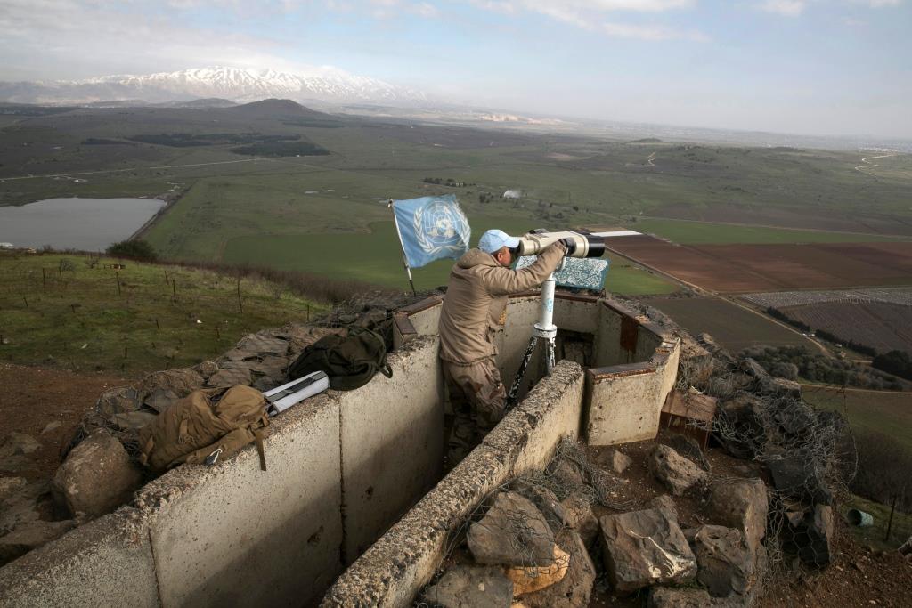 A member of the United Nations Disengagement Observer Force (UNDOF) looks through binoculars at Mount Bental, an observation post in the Golan Heights. January 28, 2015.