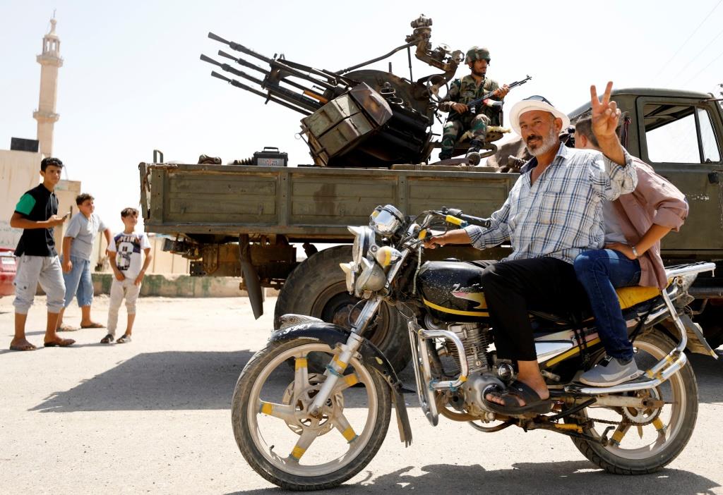 A man gestures as he rides a motorbike in Deraa, Syria, July 4, 2018.