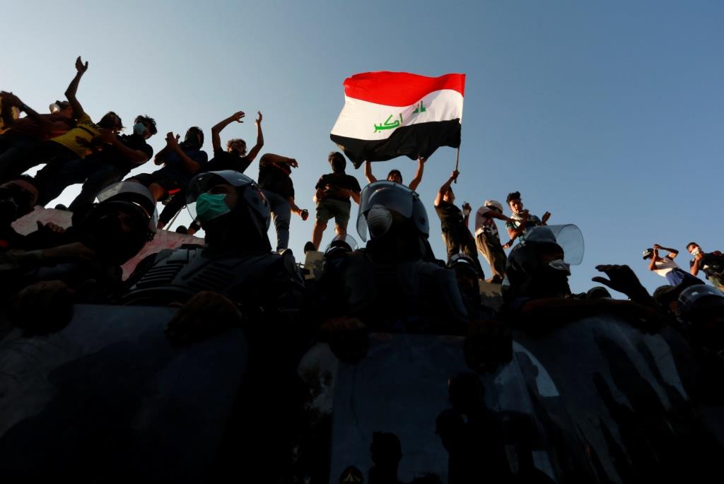 Iraqi protesters stand on concrete blast wall during a protest near the building of the government office in Basra, Iraq September 6, 2018.