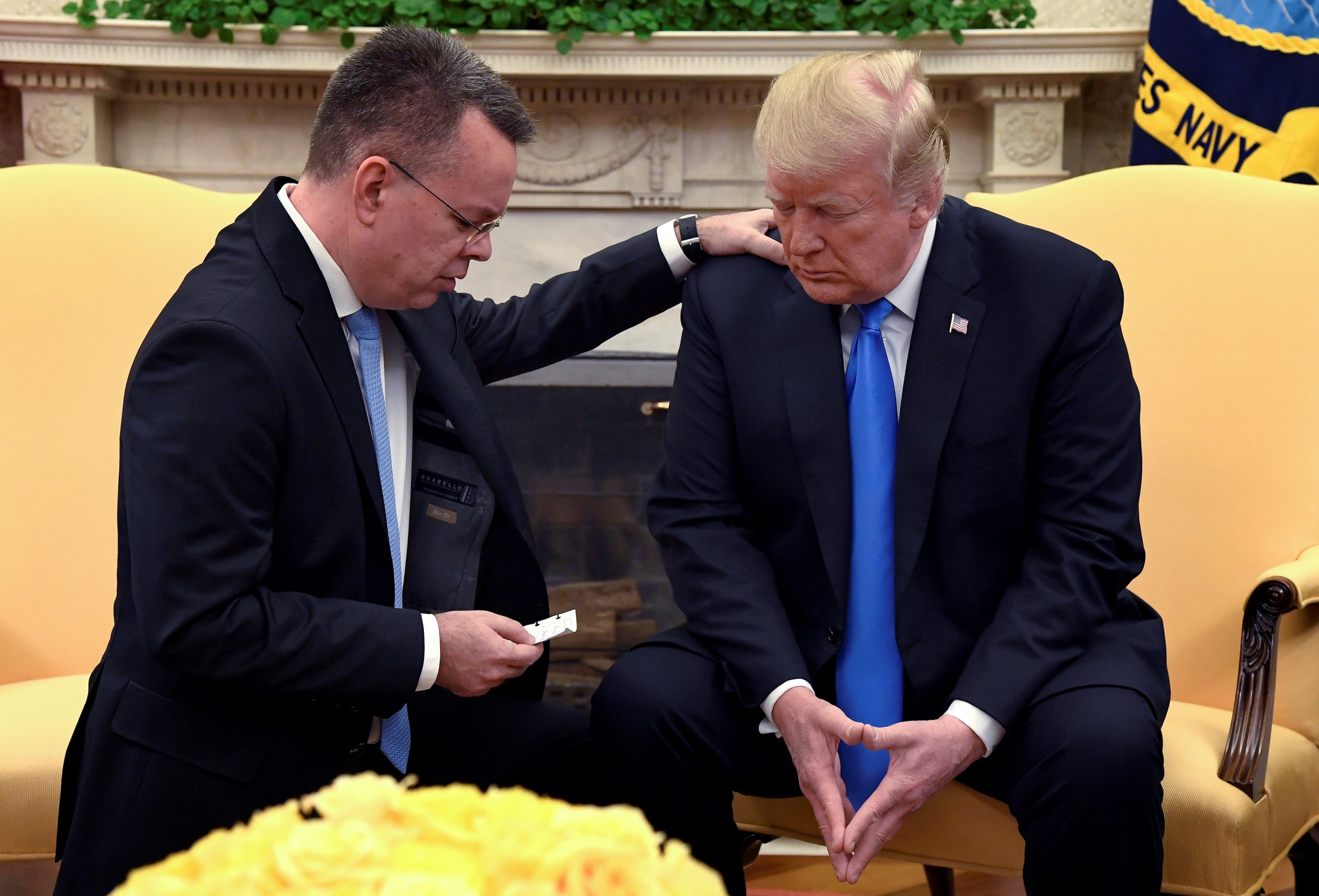 U.S. President Donald Trump closes his eyes in prayer along with Pastor Andrew Brunson, after his release from two years of Turkish detention, in the Oval Office of the White House, Washington, U.S., October 13, 2018.