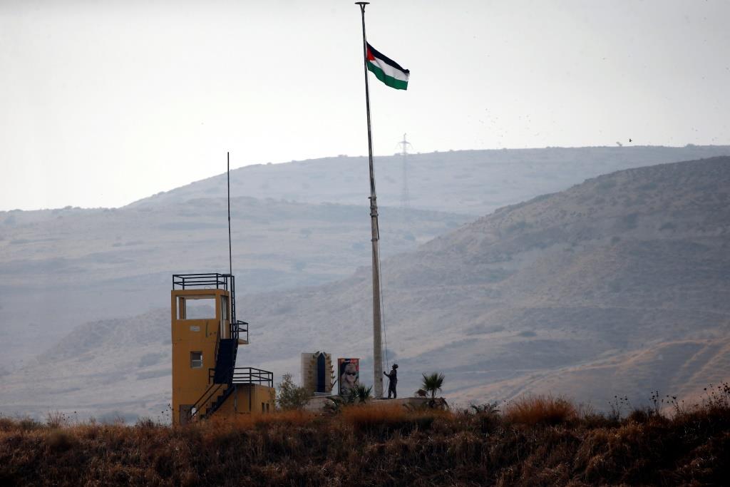 A Jordanian soldier pulls a Jordanian national flag in an outpost at the border area between Israel and Jordan at Naharayim, as seen from the Israeli side October 22, 2018.