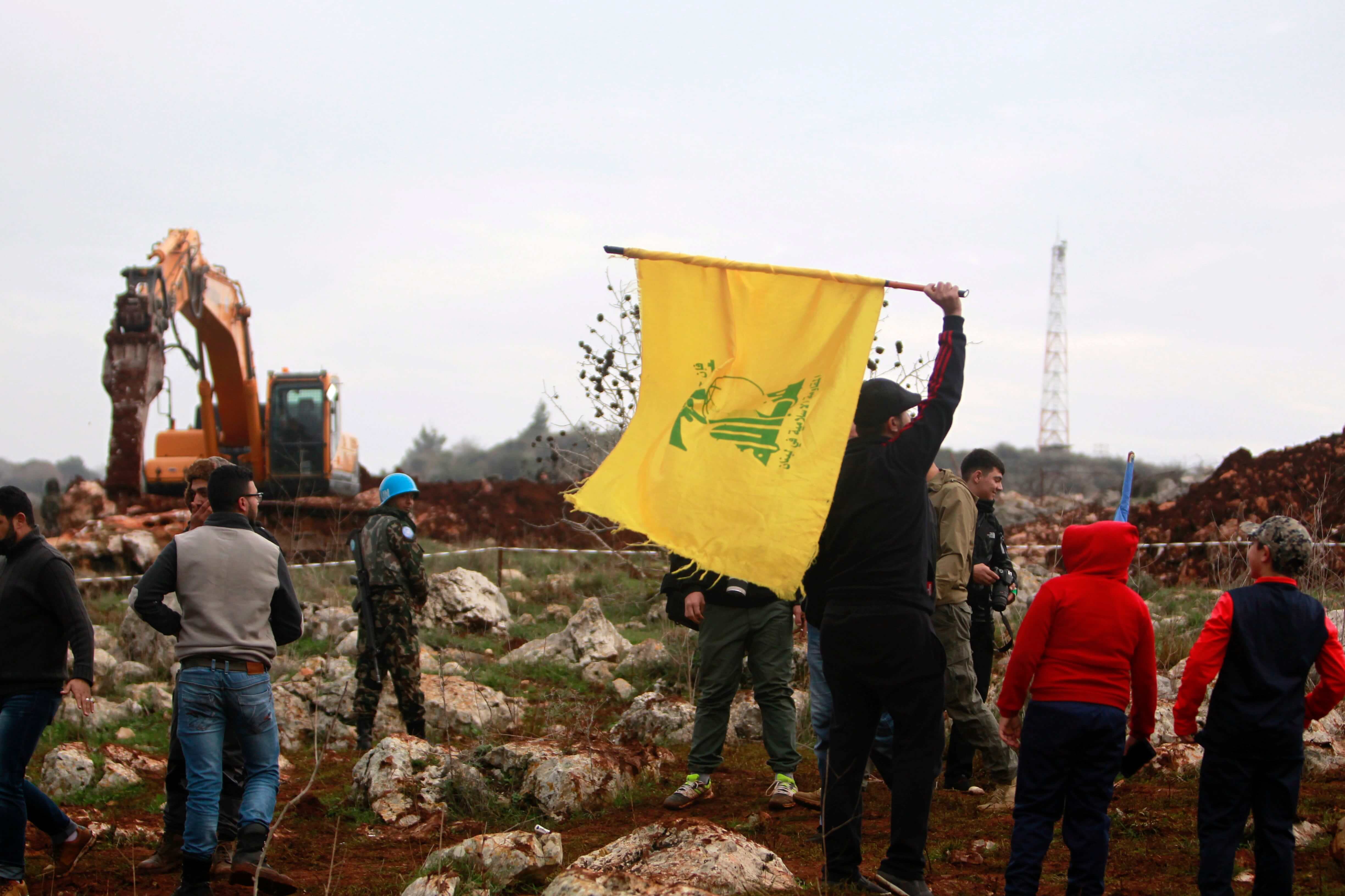 A man holds a Hezbollah flag at Meis al-Jabal village in south Lebanon, December 9, 2018.