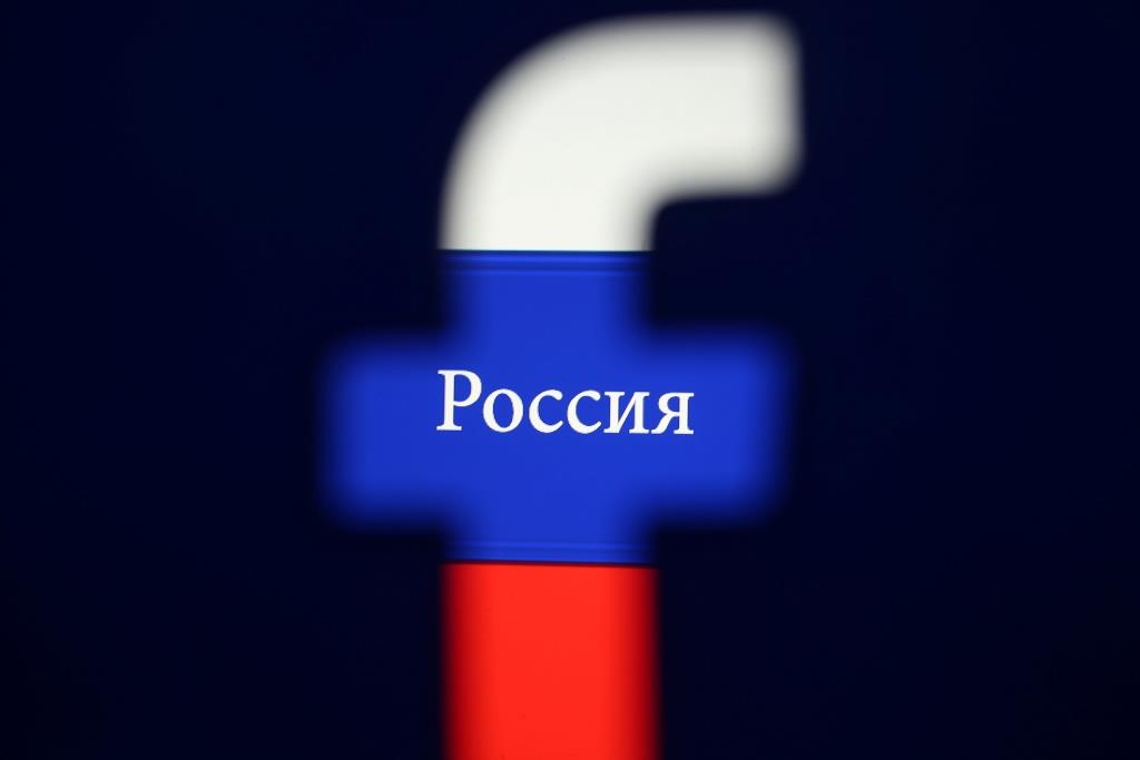 A 3D printed Facebook logo is seen in front of a displayed Russian flag in this photo illustration taken on August 3, 2018.