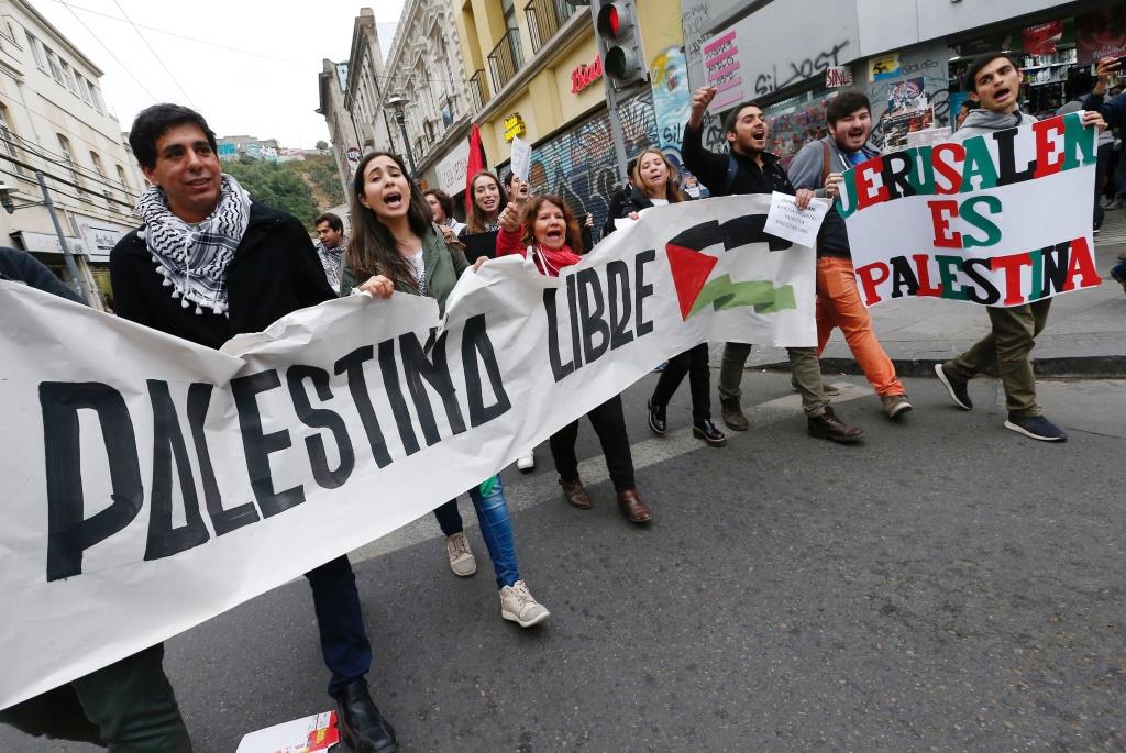 Supporters and members of Palestinian communities hold placards that read: