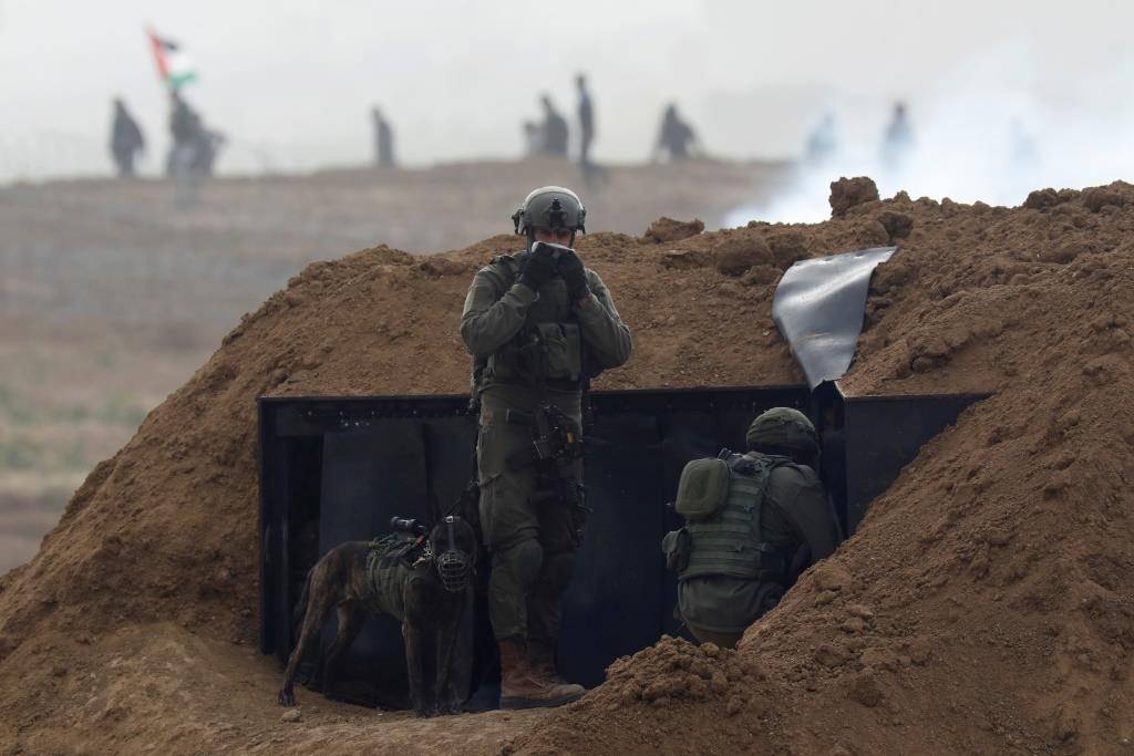 Israeli soldiers wait in position near the border fence between Israel and the Gaza Strip, March 30, 2019