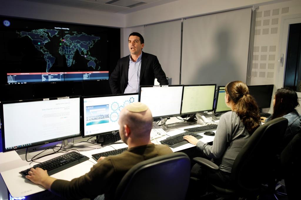 Lavy Shtokhamer, director of Israel's Computer Emergency Response Centre (CERT) stands in front of screens displaying a world map and other data as employees work at a cyber hotline facility in Beersheba, southern Israel February 14, 2019.
