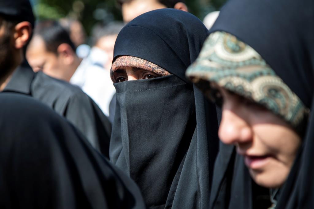 People attend a ceremony to burry remainings of 150