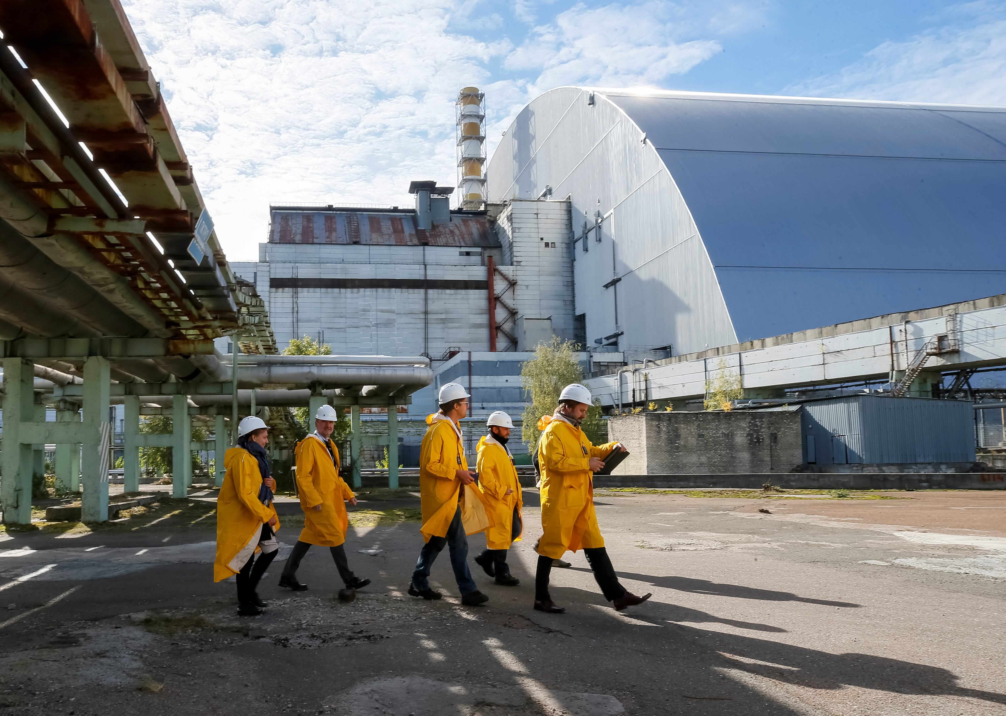 Visitors walk past a new Safe Confinement arch covering the damaged fourth reactor of the Chernobyl nuclear power plant. Ukraine, October 5, 2018.