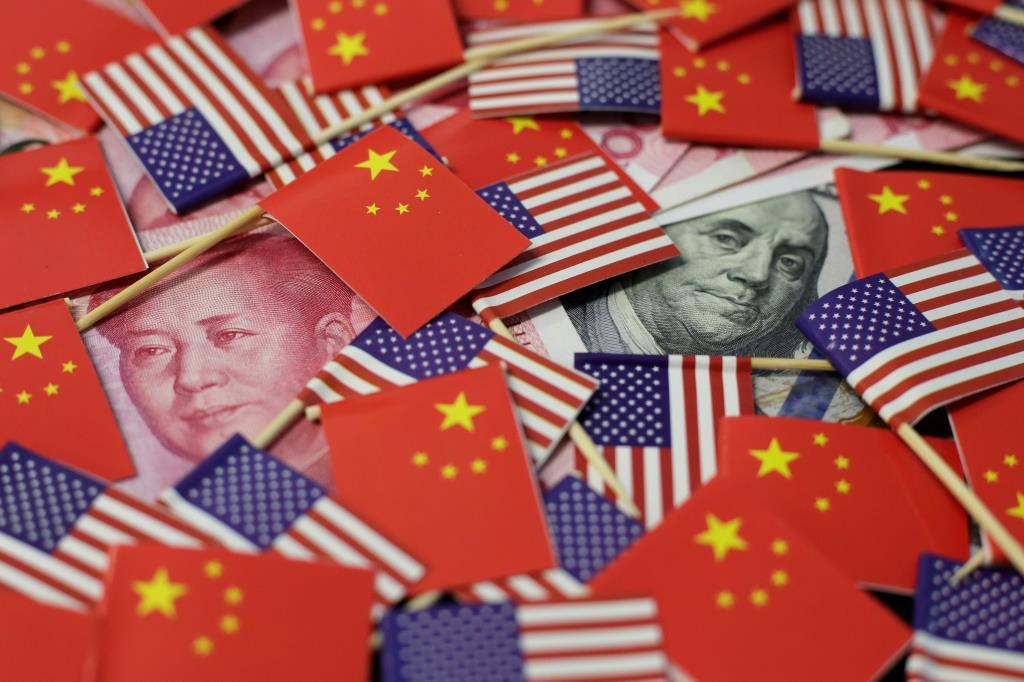 A U.S. dollar banknote featuring American founding father Benjamin Franklin and a China's yuan banknote featuring late Chinese chairman Mao Zedong are seen among U.S. and Chinese flags in this illustration picture taken May 20, 2019.