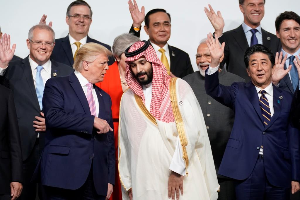 U.S. President Donald Trump speaks with Saudi Arabia's Crown Prince Mohammed bin Salman during family photo session with other leaders and attendees at the G20 leaders summit in Osaka, Japan, June 28, 2019.