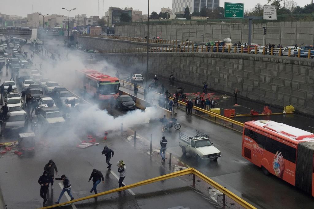 Riot police tries to disperse people as they protest on a highway against increased gas price in Tehran, Iran November 16, 2019.