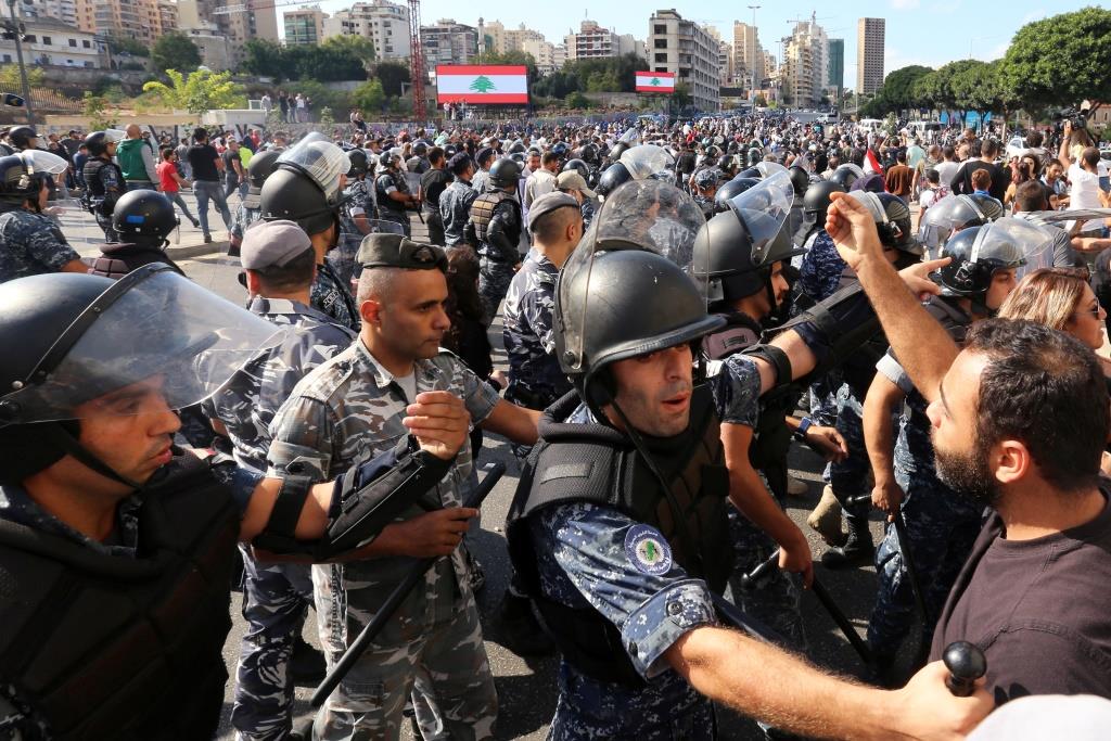 Anti-riot police stand guard after supporters of the Lebanese Shi'ite groups Hezbollah and Amal fought with protesters at a roadblock on a main road in Beirut, during ongoing anti-government protest, Lebanon October 29, 2019.