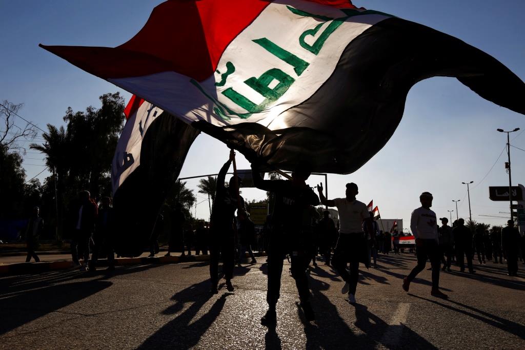 Iraqi demonstrators carry the Iraqi flag during ongoing anti-government protests in Najaf, Iraq December 20, 2019.