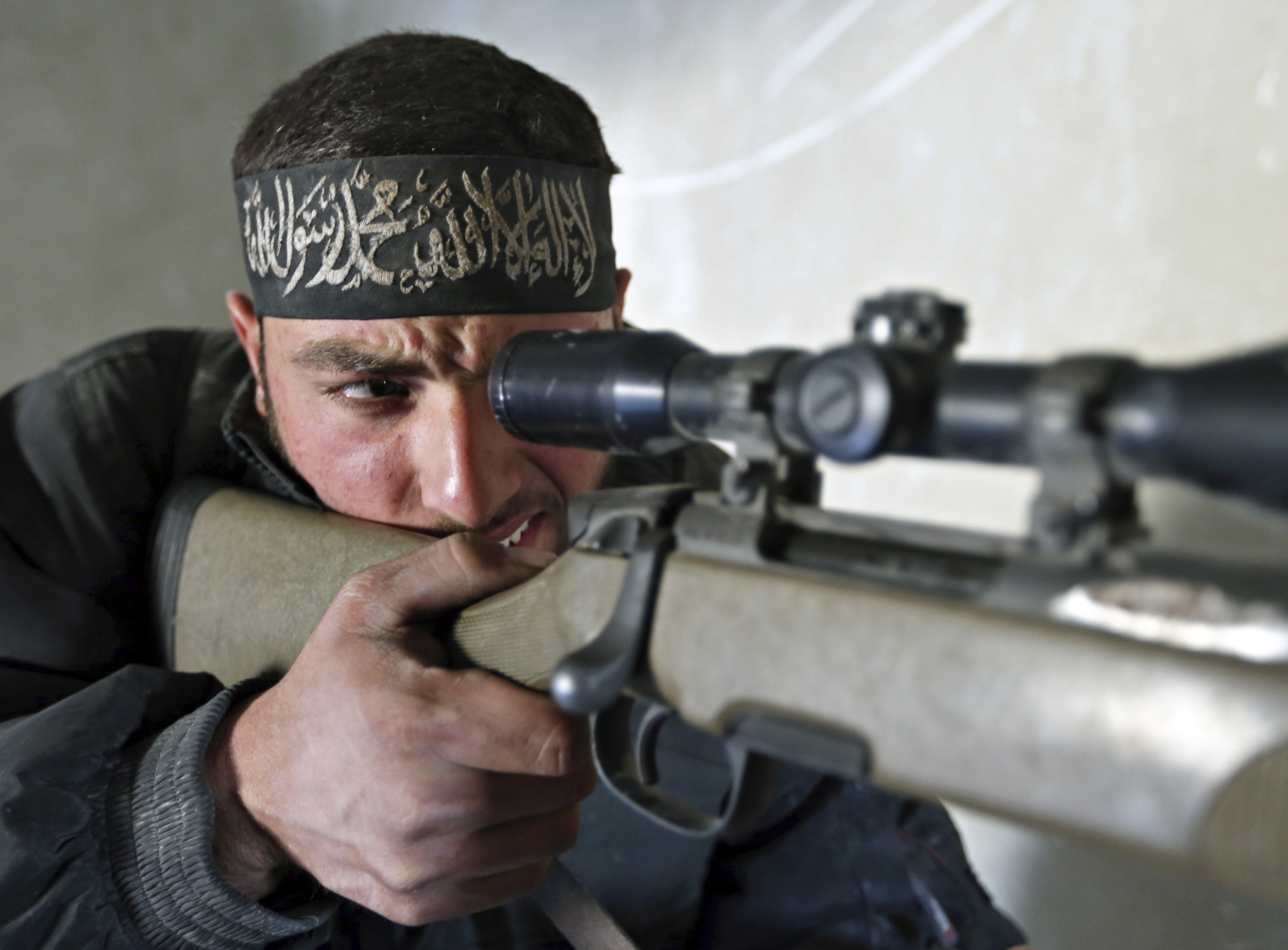 A fighter from the Free Syrian Army's Tahrir al Sham brigade aims a sniper rifle before firing at Syrian Army soldiers during heavy fighting in Mleha suburb of Damascus January 26,