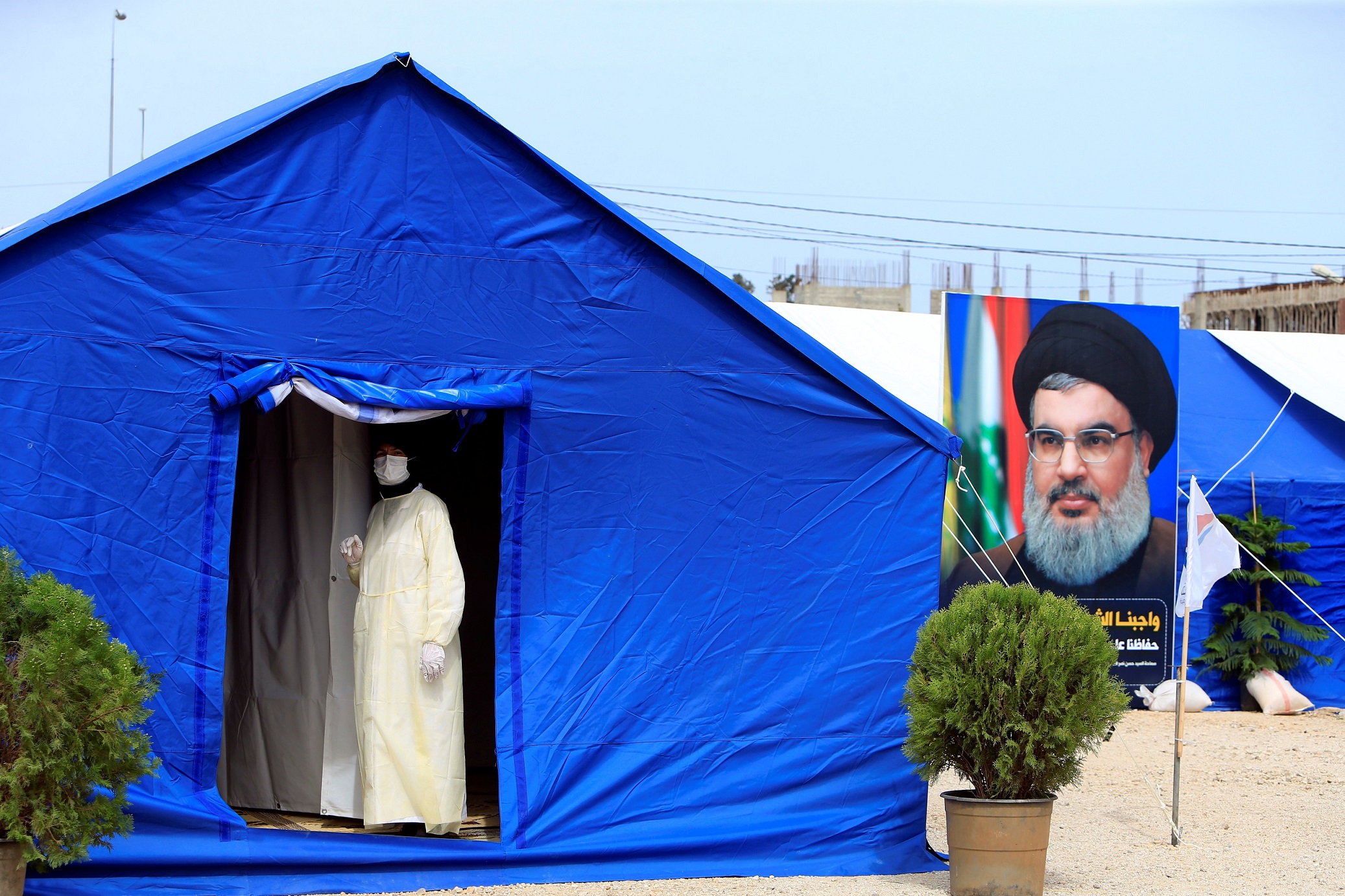 A medic wearing protective gear stands inside a tent facility set up by Hezbollah to test for coronavirus disease (COVID-19) in al-Ghaziyeh, southern Lebanon March 31, 2020. Picture taken March 31, 2020.