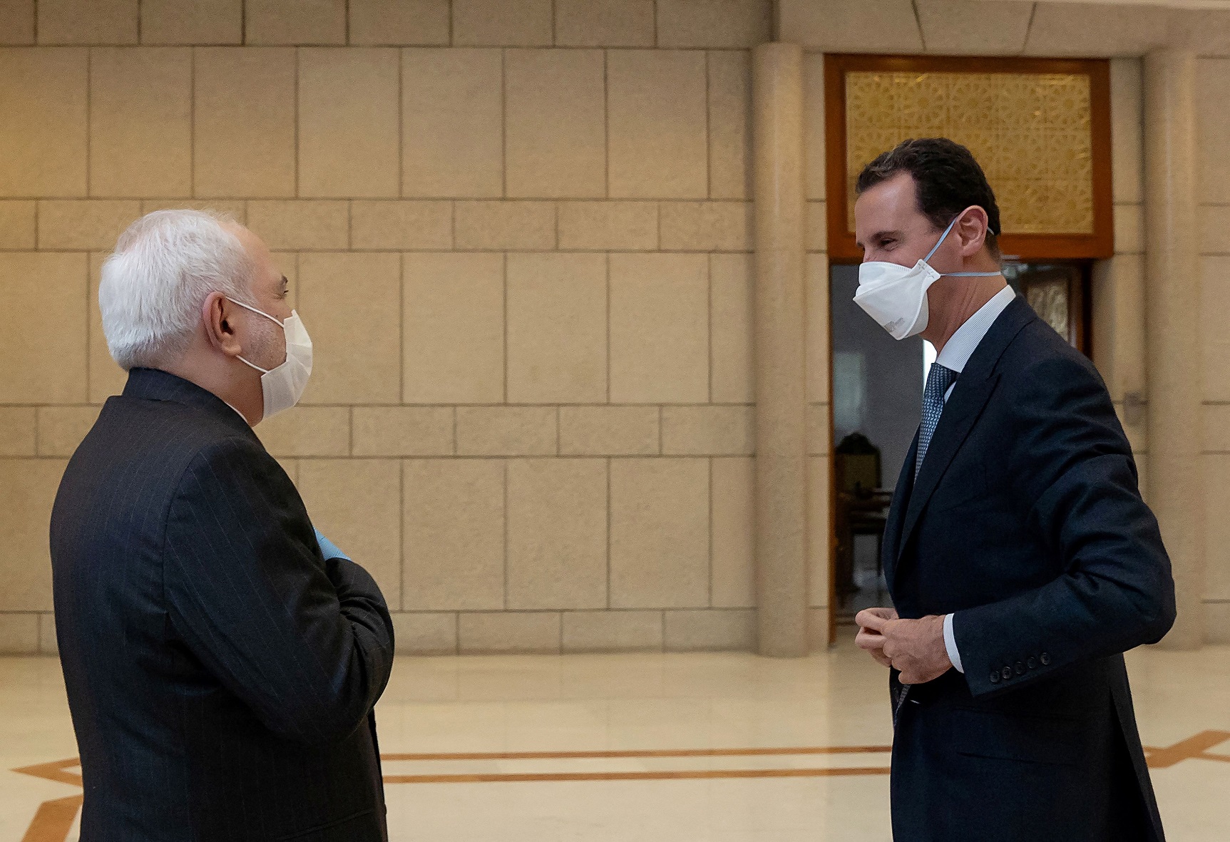 Syria's President Bashar al-Assad and Iran's Foreign Minister Mohammad Javad Zarif, wearing face masks as protection against the spread of the coronavirus disease (COVID-19), meet in Damascus, Syria.