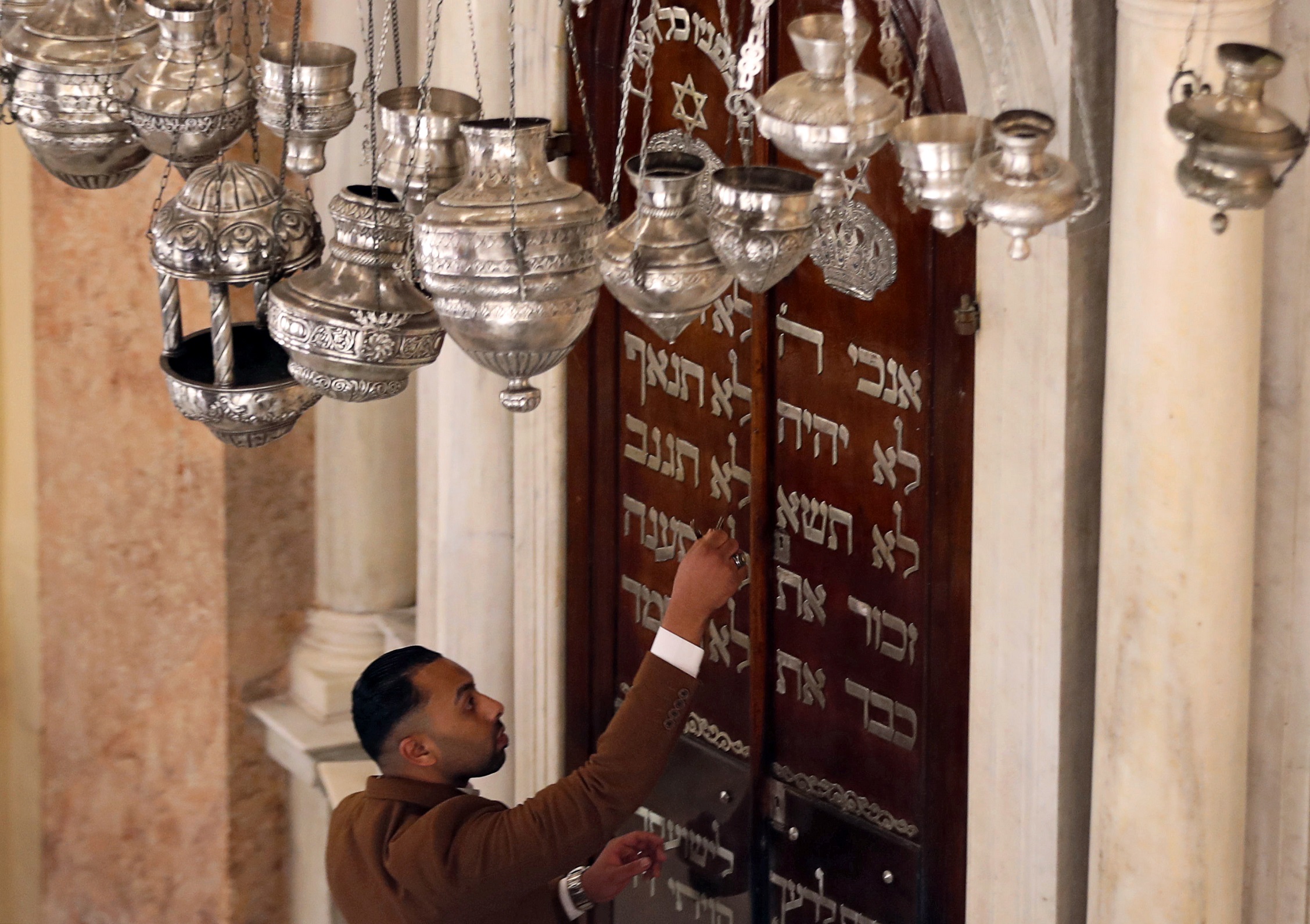 A man opens the door of a bima inside the Eliyahu Hanavi Synagogue during its reopening after the completion of a restoration project in Alexandria